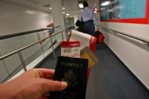 a hand holding a passport and boarding pass