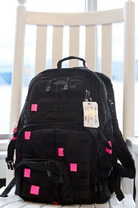 a black backpack with pink labels