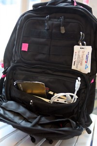 a black backpack with a white tag and a white cord