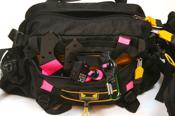 a black bag with pink straps and a pocket