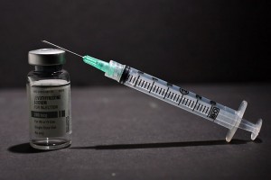 a syringe with a needle in the middle of a vial