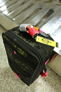 a black suitcase with yellow tags on it
