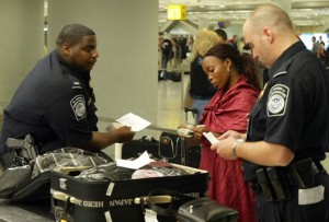 a police officer checking out a woman's luggage