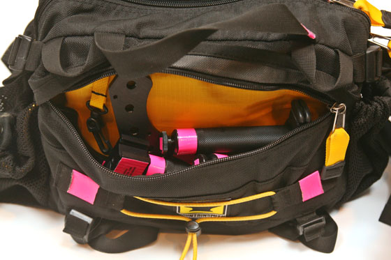 a black and yellow bag with pink straps