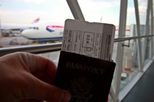 a hand holding a passport and boarding pass