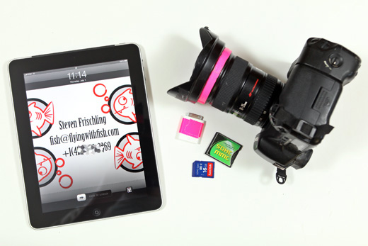 a camera and a tablet next to memory cards