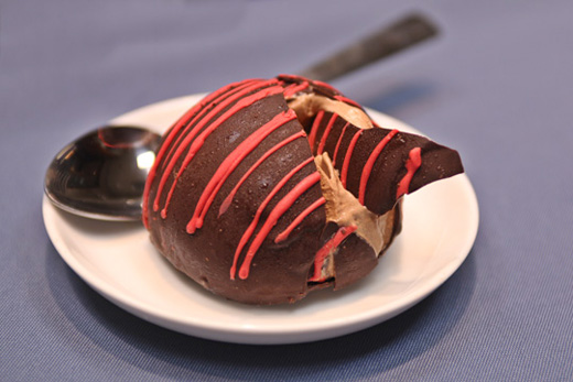 a chocolate ice cream on a plate with a spoon