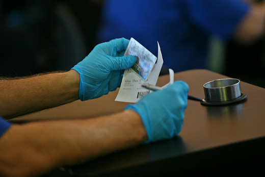 a person wearing blue gloves holding a piece of paper