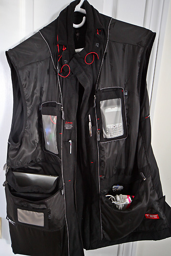 a black vest with a pocket and a phone in it
