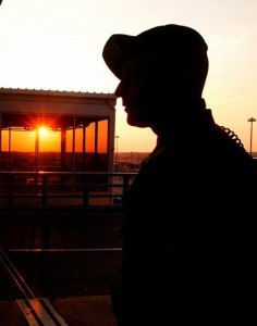 a silhouette of a man standing in front of a sunset