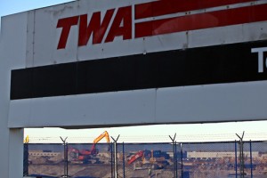 a large sign with construction equipment behind it