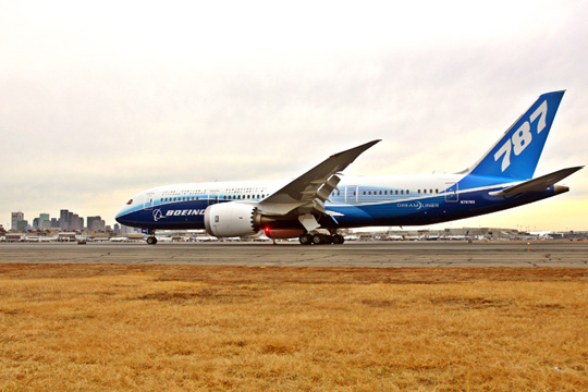 a blue and white airplane on a runway