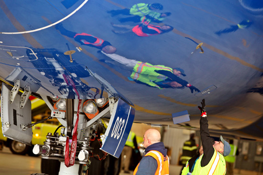 workers touching the underside of a plane
