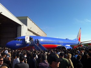 a large group of people standing around an airplane