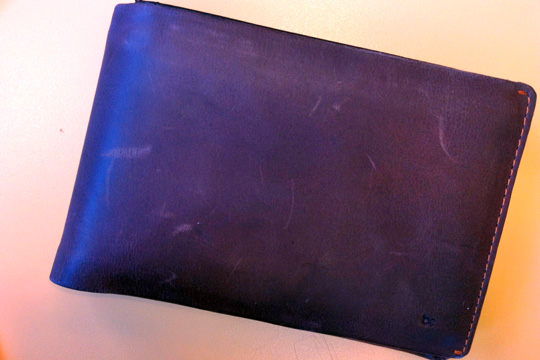 a purple leather wallet on a white surface