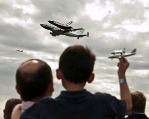 a group of people watching a plane flying