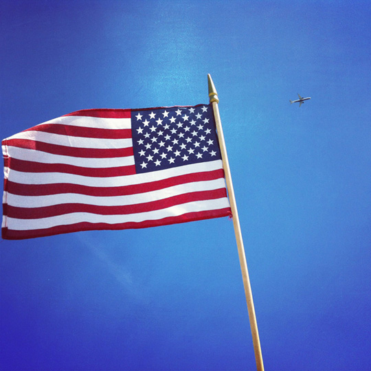 a flag with a plane in the background
