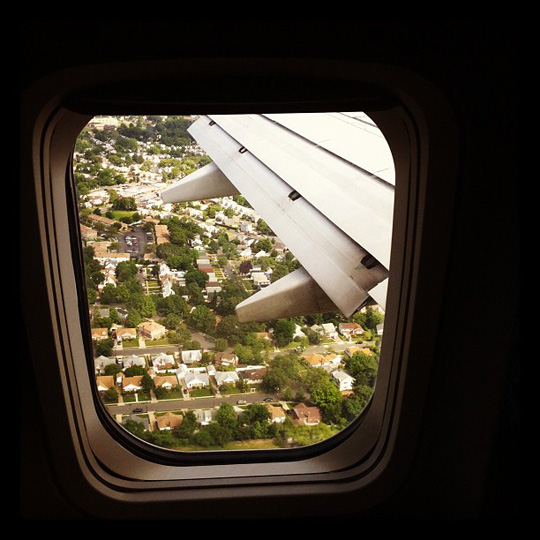 an airplane wing and city view from an airplane window
