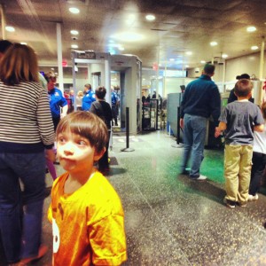 a boy standing in a room with people around