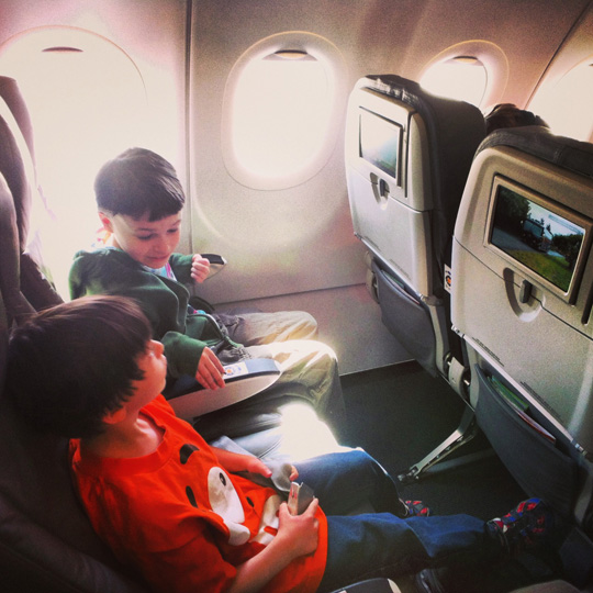 two boys sitting on an airplane