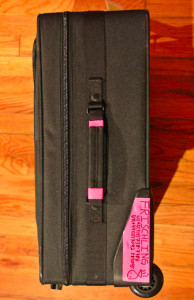 a black suitcase with pink label