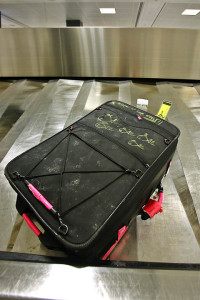 a black suitcase with pink handles